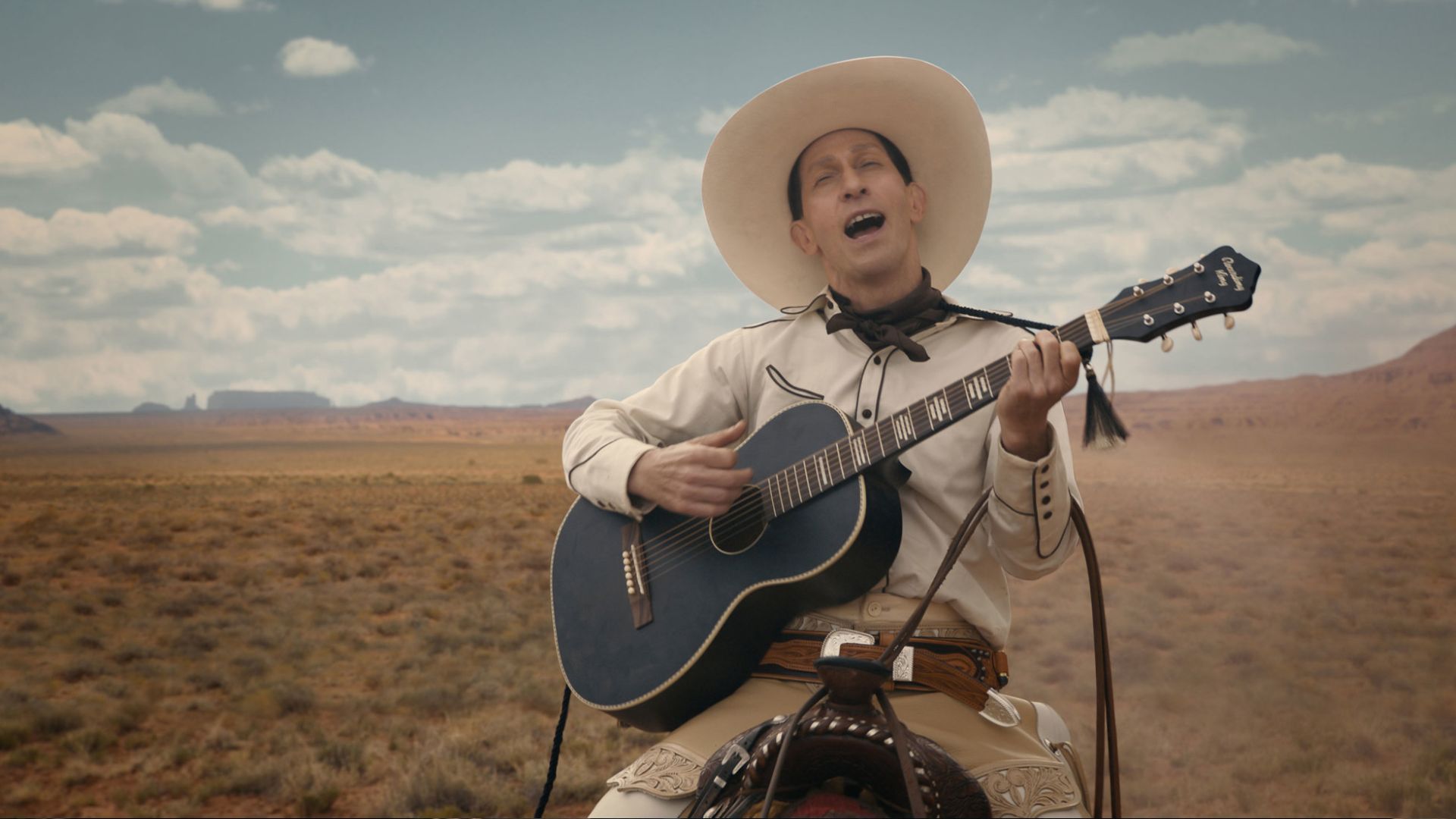 تیم بلیک نلسون در فیلم The Ballad of Buster Scruggs در بیابانی گیتار می‌زند