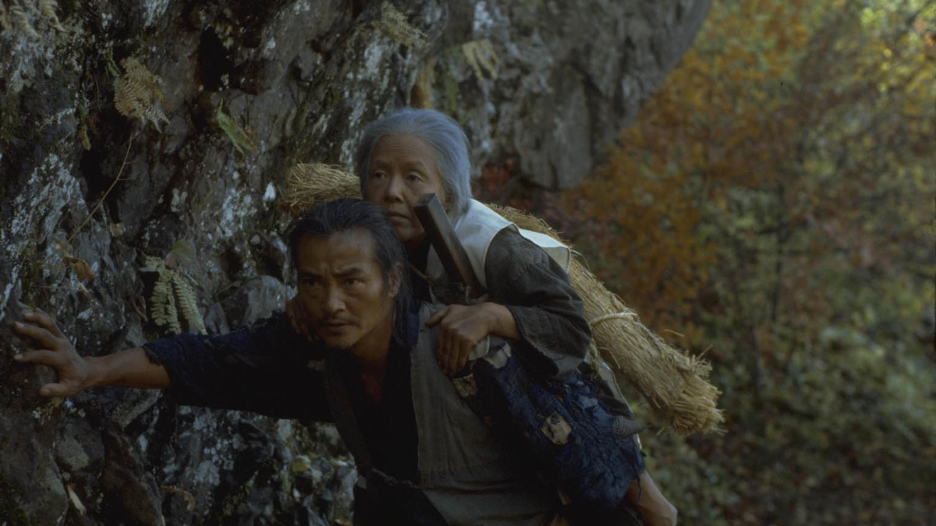 مردی در حال بردن مادرش به کوهستان در فیلم تصنیف نارایاما